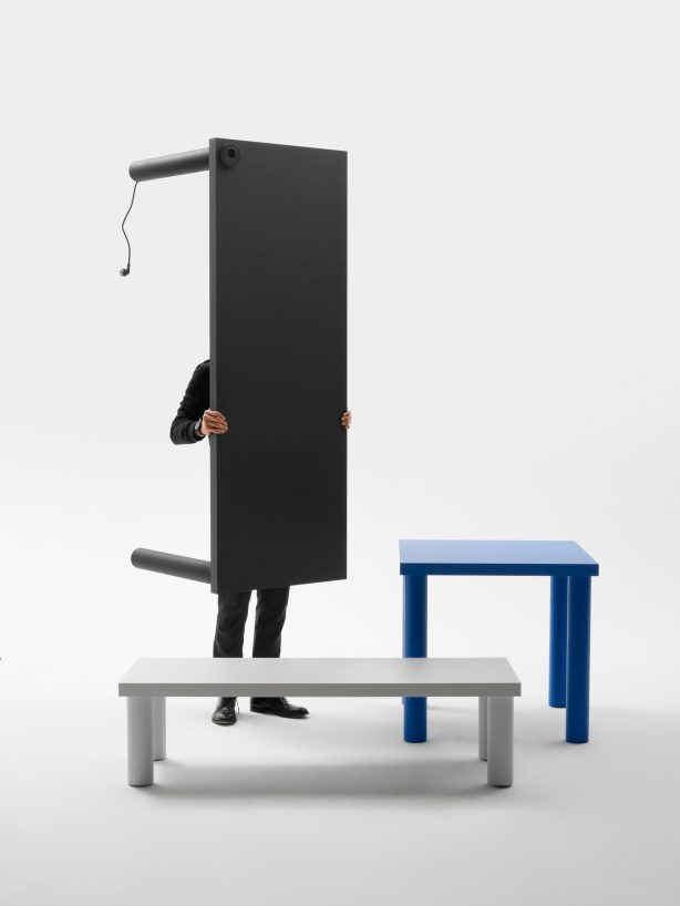 Gumpo Pipo lighweight table in small grey, medium blue and a tall black table with power socket carried by a person.