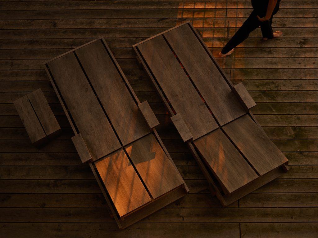 outdoor top view of aged oak sunbeds during sundowner. Foeppl Collection by Relvaokellermann for Holzrausch Editions.
